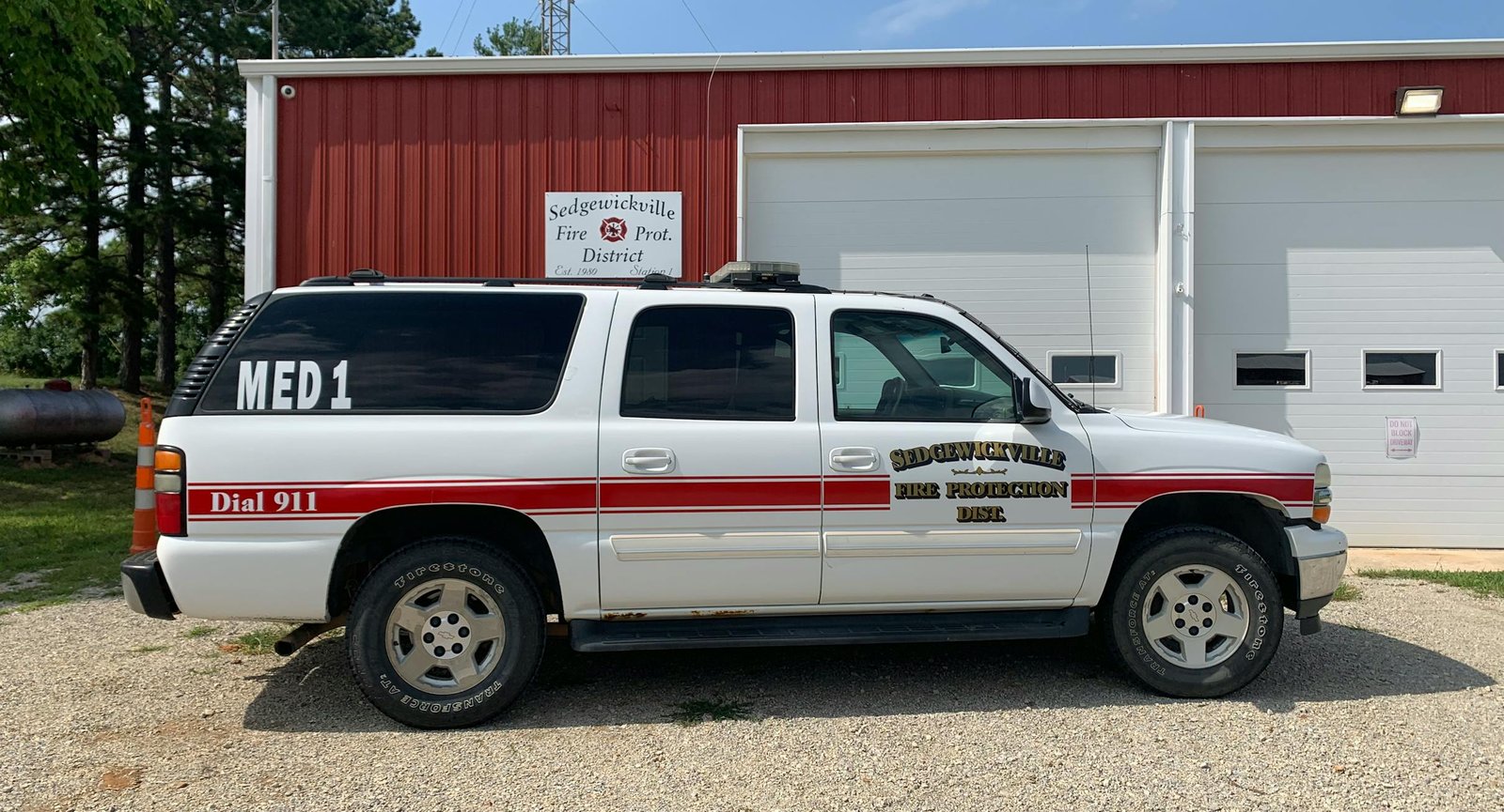 A white medical response suv in front of a fire station